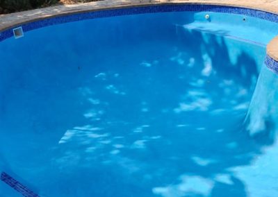 Finished custom concrete pool project with blue interior.