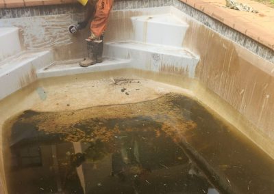 Cleaning a dirty concrete pool.