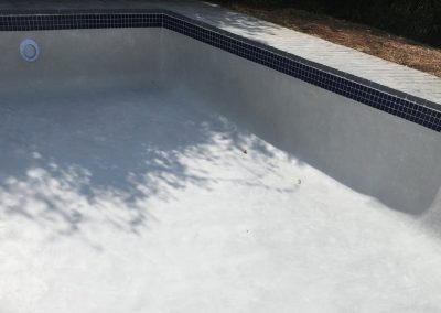 Cleaned and renovated white interior concrete pool.